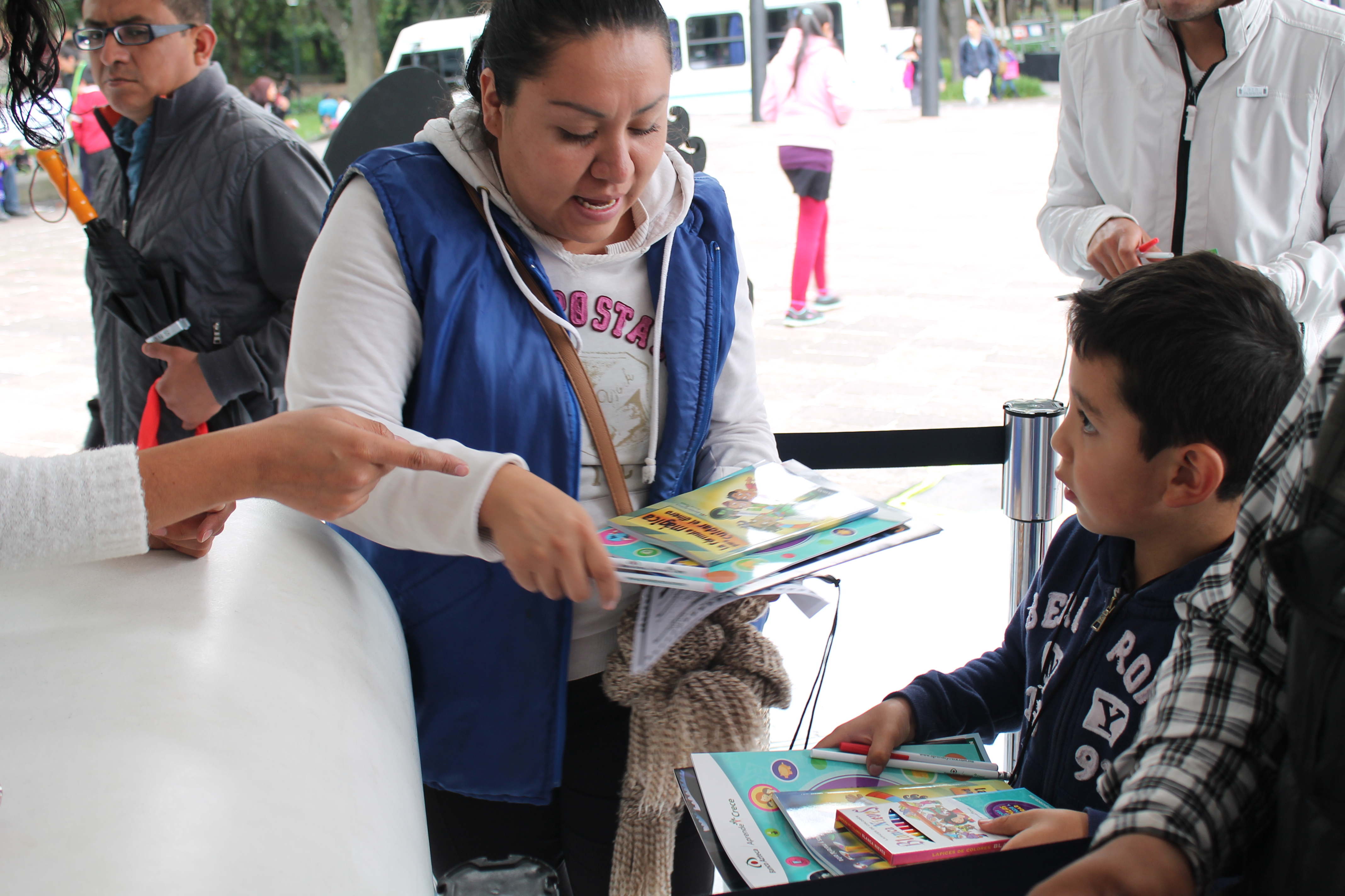 Mamá disfrutando con sus hijos los premios que ganaron en el stand de Banco Azteca